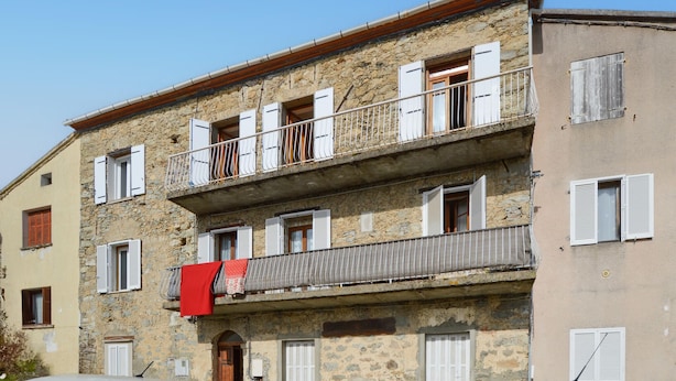 A multi-story stone building with balconies, white shutters, and a visible laundry hanging on one of the balconies. - 2 bedroom gorgeous apartment in Poggio Di Nazza (Poggio Di Nazza)