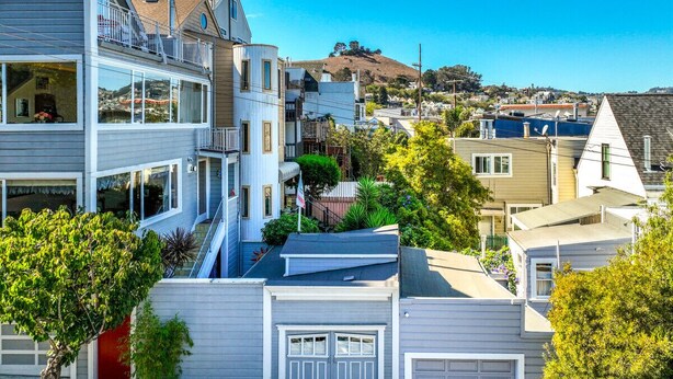 Ein Wohngebiet mit mehreren H äusern, darunter ein zweistöckiges Haus mit Balkon und Garage.