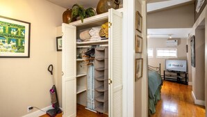 Ein kompakter Wohnbereich mit begehbarem Kleiderschrank, Essbereich und Schlafzimmer, das ein Bett und einen Fernseher bietet.