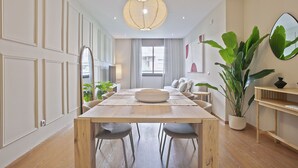 Un comedor moderno con una mesa de madera, cuatro sillas y una planta grande en maceta.