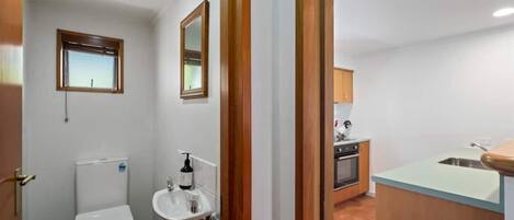 A compact kitchen with a sink, stove, and cabinets.