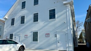 Un bâtiment blanc doté de nombreuses fenêtres et d’une porte de garage.