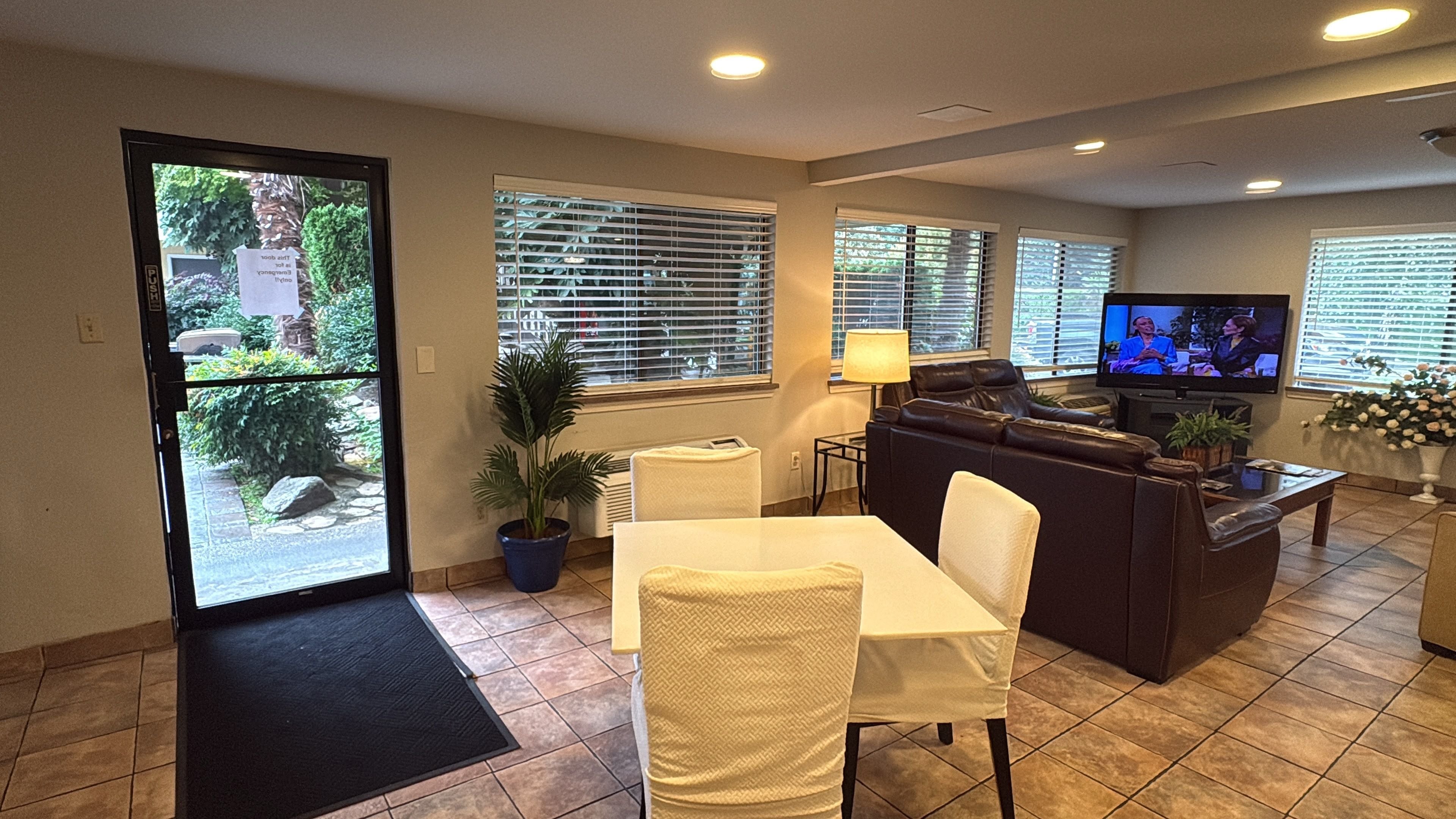 A living room with a sofa, a coffee table, a TV, and a dining area with a table and chairs.