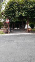 Una calle de acceso para bomberos con un letrero de 'prohibido estacionar', un banco y una jardinera con una planta grande.