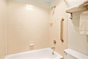 Bañera con ducha, toallas, jabón, shampoo