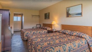 A hotel room with two beds, a desk, a chair, a lamp, and a painting on the wall. - Hotel Viewmont Residency Ltd. (Logan Lake)