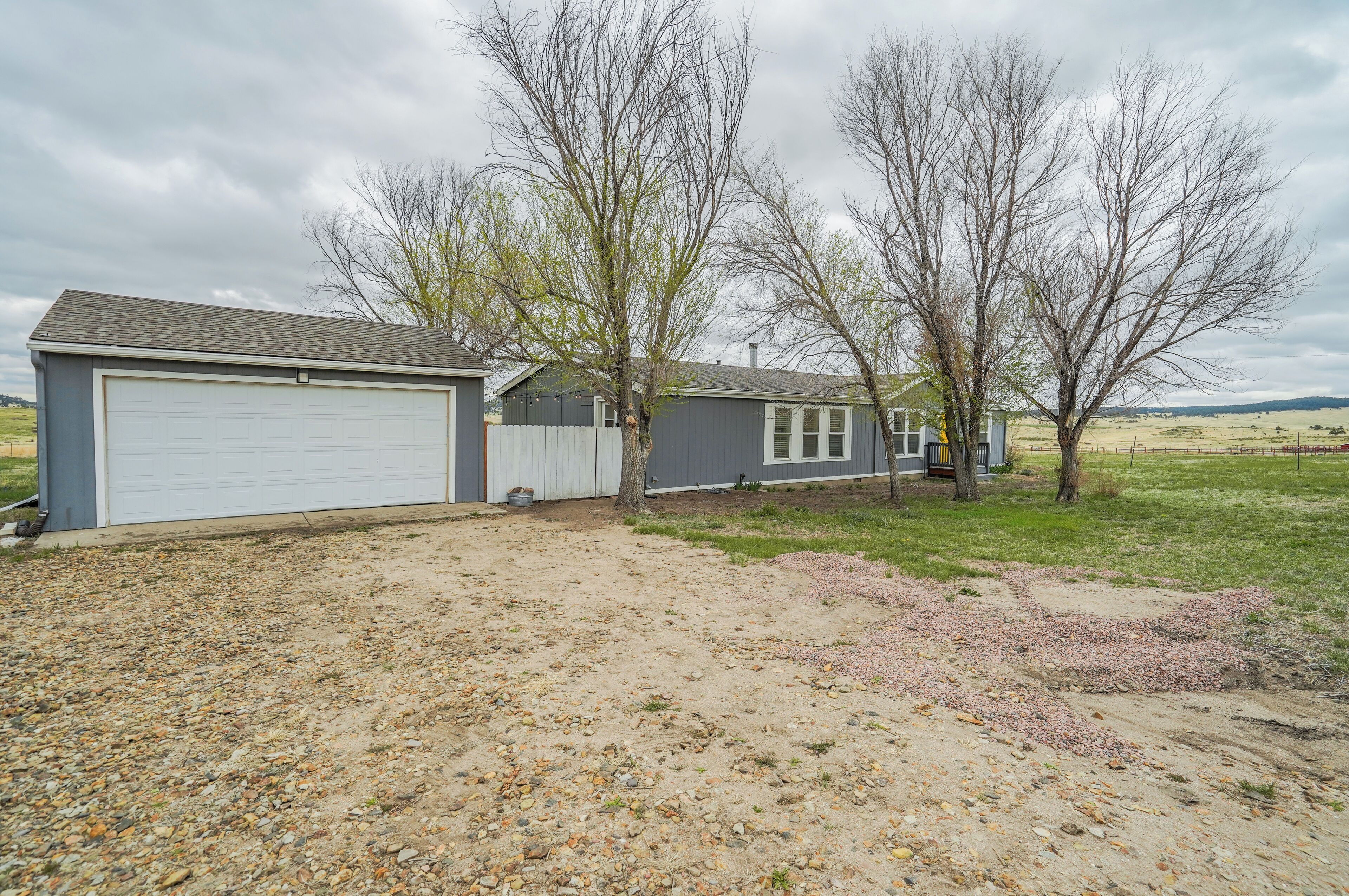 A residential property with a garage, a shed, and a house with a front yard.