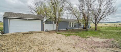 A residential property with a garage, a shed, and a house with a front yard.