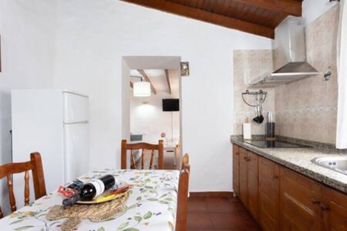 A compact kitchen with a built-in oven, a sink, and wooden cabinets.