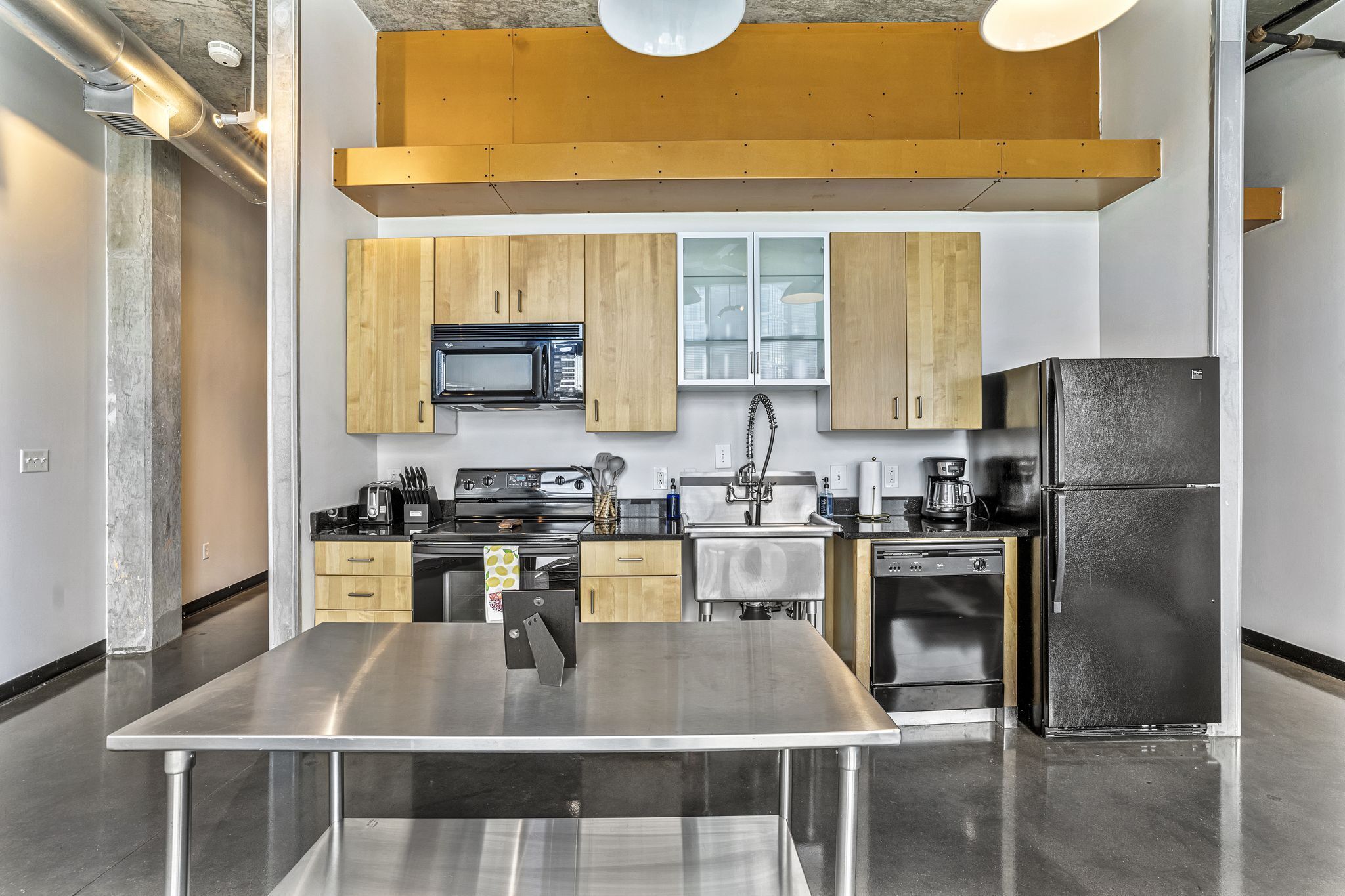 Una cocina moderna con electrodomésticos de acero inoxidable, armarios de madera y una isla central grande.