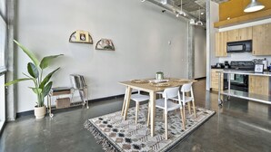 A modern kitchen with wooden cabinets, a microwave, and a stainless steel countertop. - *NEW* Trendy & Central Gulch Condo! (Nashville)