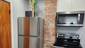 Eine Küche mit einem Edelstahlkühlschrank, einer Mikrowelle und einem Backofen.