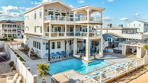 A multi-story residential building with a pool, balconies, and outdoor seating areas. - Pura Vida | Oceanfront | Private Pool, Hot Tub, and Dog Friendly (Virginia Beach)