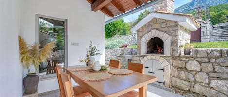 Un comedor con chimenea de piedra, una mesa de madera y sillas.