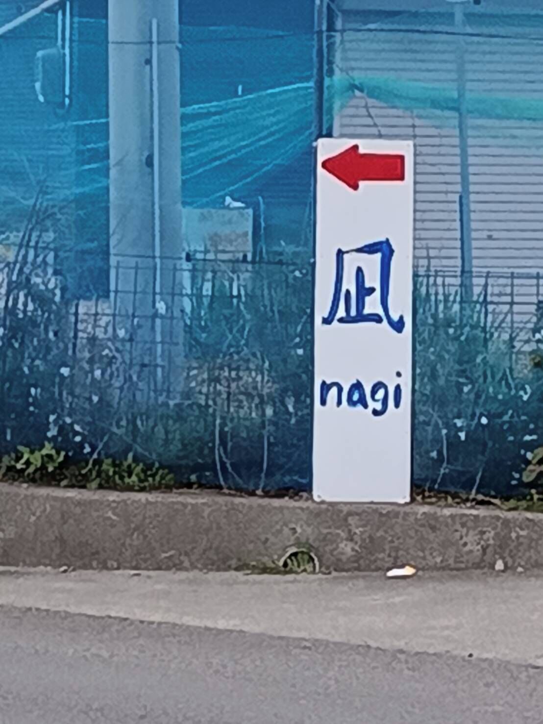 A directional sign with Japanese characters and an arrow pointing left.