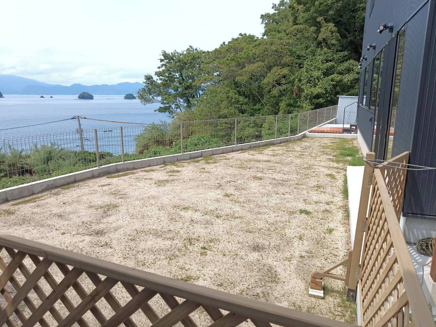 Un patio de grava con vistas al mar y a islas lejanas.