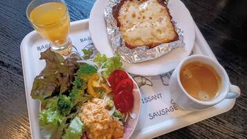 A meal tray with a salad, a baked dish, and a cup of tea.