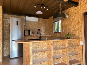 Een koelkast met diepvriezer, een microgolfoven, een kookplaat