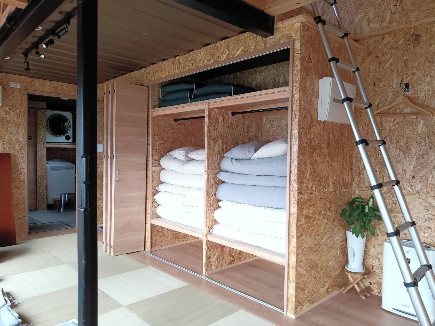 Una habitación compacta con armario empotrado, lavadora y una escalera.