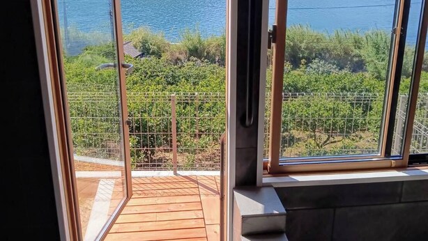 Un balcó amb vista a un llac i a les muntanyes.