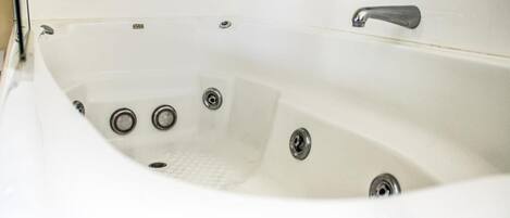 A white bathtub with a single faucet and three drain holes.