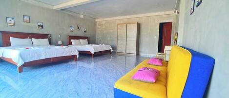 A hotel room with two beds, a sofa, and a wardrobe.
