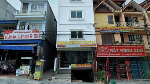 A row of buildings with signs for a hotel, a coffee shop, and a massage parlor. - Sapa Happy Hotel (Sa Pa)