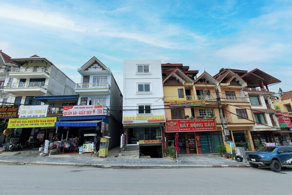 A row of multi-story buildings with various businesses, including a hotel, a restaurant, and a convenience store.