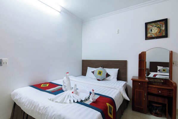A hotel room with two beds, a wooden dresser, a mirror, and a painting on the wall. - Sapa Happy Hotel (Sa Pa)