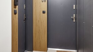 Un ascenseur moderne doté de deux portes, numérotées 07 et 08, et d’un petit paillasson à l’entrée.