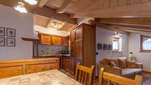 Una cucina accogliente con mobili in legno, un tavolo da pranzo e un divano nella zona living.