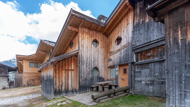 Un edificio in legno con un vialetto in pietra che conduce a una panchina di legno.