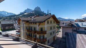 Un edificio de varios pisos con balcones, vistas despejadas a las montañas y una señal de 'STOP' en el techo.