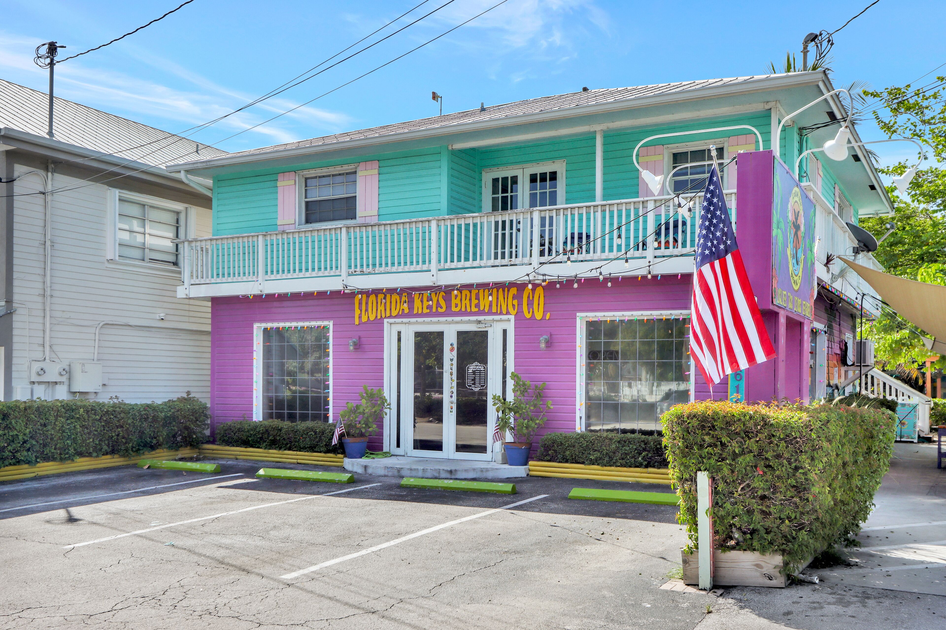 Een kleurrijk gebouw met een bord waarop staat: Florida Keys Brewing Co.