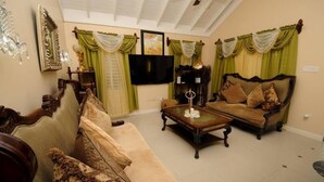 Una sala de estar con un sofá, una mesa de centro y una televisión.