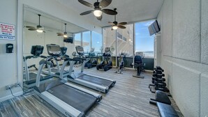 Ein Fitnessstudio mit Laufbändern, Crosstrainern und Kurzhanteln.