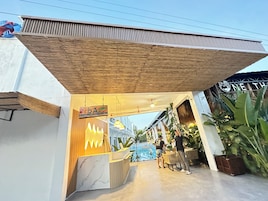 A reception area with a wooden ceiling, a marble counter, and potted plants.
