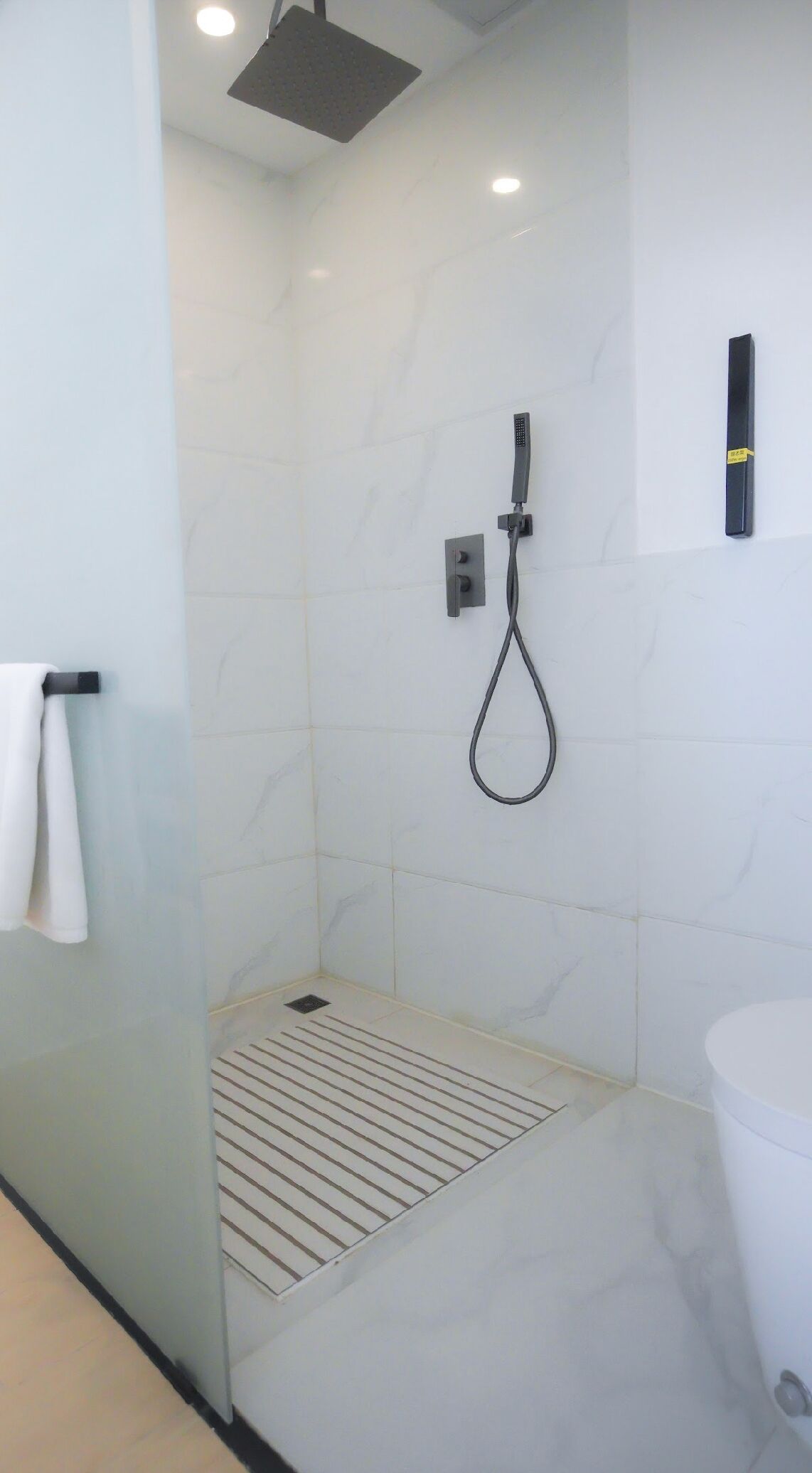 Une salle de bain moderne équipée d’une douche, de toilettes et d’un lavabo.