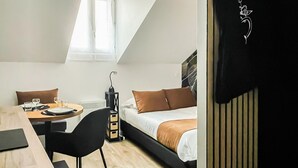 Une chambre moderne et compacte, équipée d’un lit, d’une table à manger et d’une chaise.