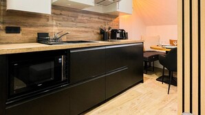Une cuisine moderne équipée d’un four à micro-ondes encastré, d’un évier et d’une machine à café.