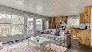 A modern kitchen with wooden cabinets, a built-in microwave, and a large window. - Riverbend Cabin Hot Tub, River Front Dog Friendly (Rhododendron)
