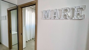 A hallway with a mirror and a wall-mounted sign that reads "MARE". - TSG 4 (Apartment + Extra Overview Terrace) (Ugento)