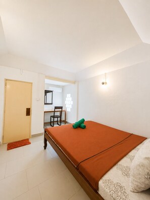 Quarto com cama, escrivaninha e cadeira.