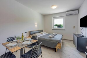 A modern bedroom with a bed, bedside table, and a TV.