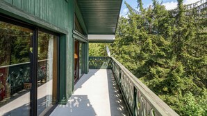 A balcony with a view of dense forest, a glass door, and a metal railing. - Residence Montana Le Duplex 3BR Near to Grands Montets Ski Lift, Sleeps 6, Argentière (Chamonix), France (Argentière (Chamonix))