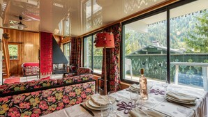 A dining area with a table set for four, a sofa, and a fireplace. - Residence Montana Le Duplex 3BR Near to Grands Montets Ski Lift, Sleeps 6, Argentière (Chamonix), France (Argentière (Chamonix))