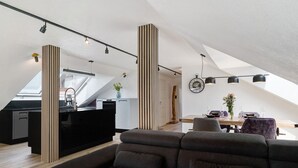 Un loft moderne comprenant une cuisine, un coin repas et une grande fenêtre.