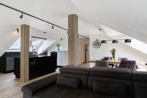 A modern loft with a kitchen, dining area, and a large window. - Apartment 'Moderne Offene Dachgeschoßwohnung' with Shared Pool, Shared Garden and Wi-Fi (Rheinau)