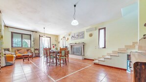 A spacious living area with a dining table, chairs, a sofa, and a fireplace. - Villa Mattalia Relax at Villa for 10, Manduria, Italy (Manduria)