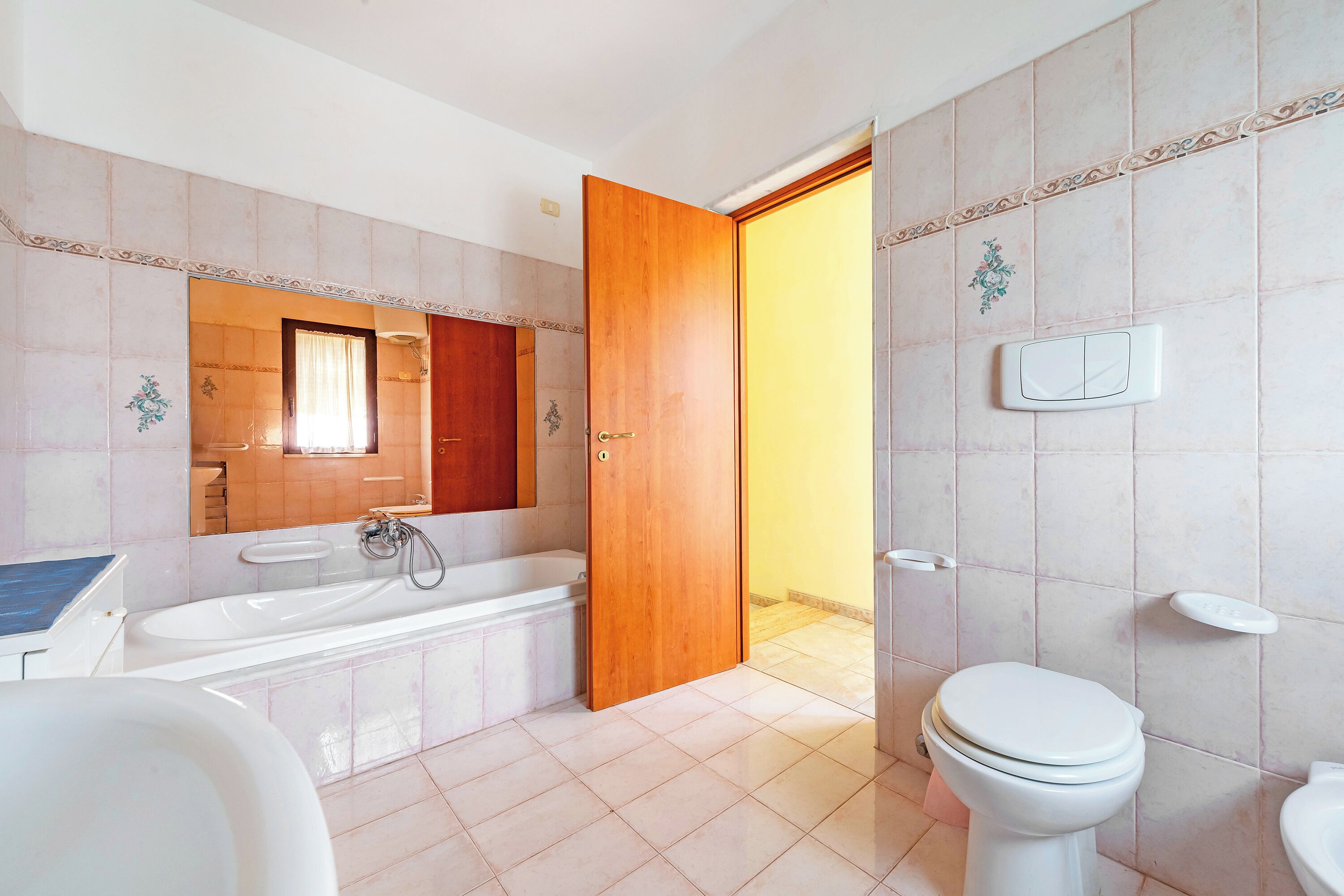 Een badkamer met een bad, toilet en wastafel.